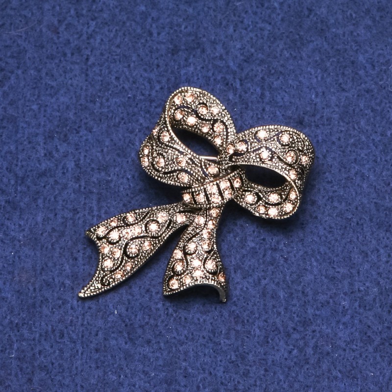¡Rebaja! Broche Lazo con strass en metal dorado